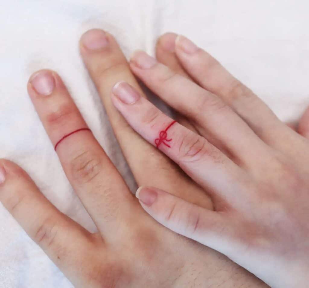 14. Eine rote Schleife auf dem Finger