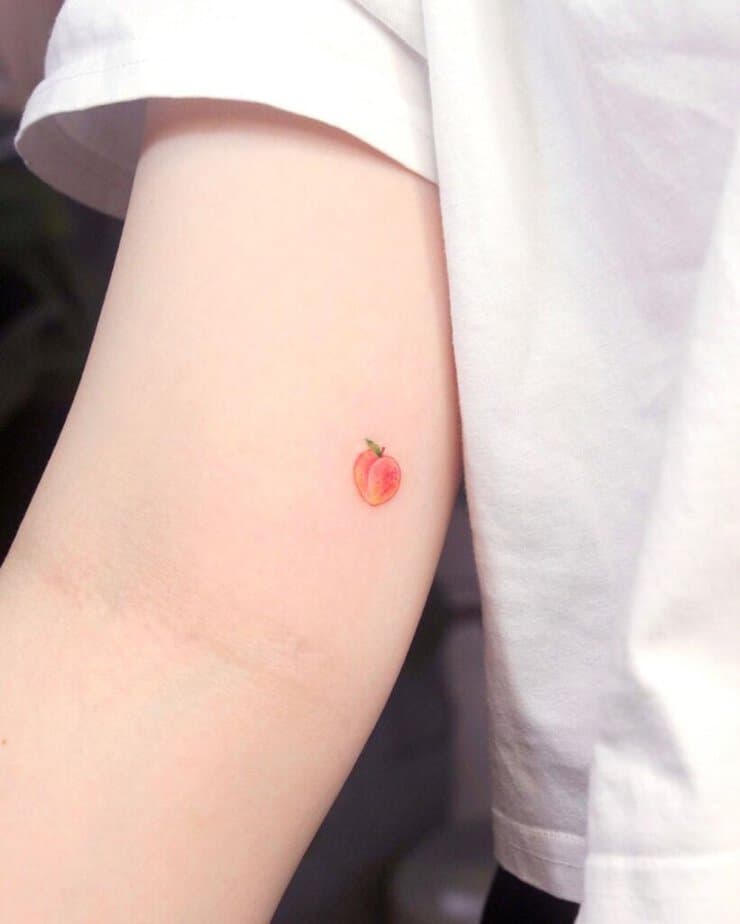 15. Ein kleines Pfirsich-Tattoo auf dem Bizeps