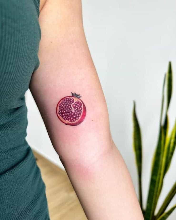 19. Ein Granatapfel-Tattoo auf dem Bizeps