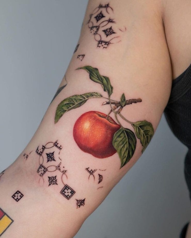 23. Ein Tattoo mit einem Apfel auf dem Bizeps