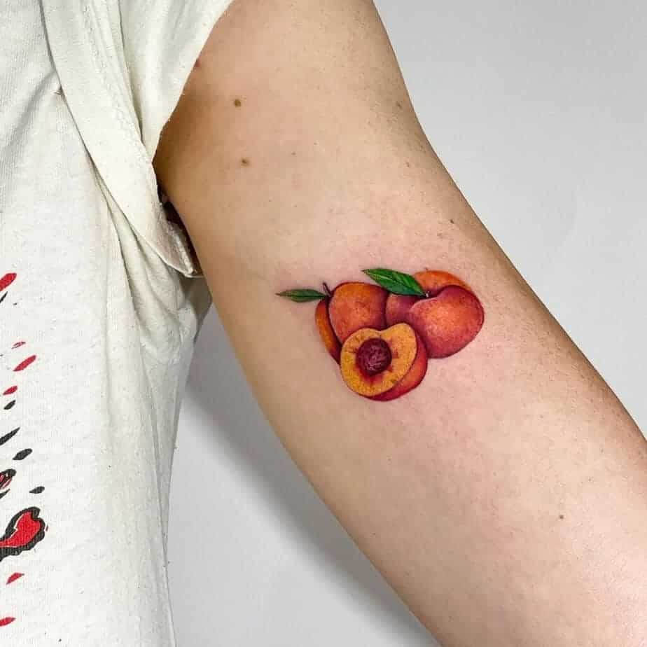 5. Ein Tattoo mit Pfirsichen auf dem Bizeps