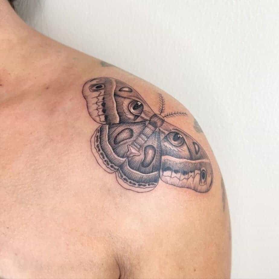 14. Ein Tattoo mit einer Motte und Katzenaugen auf der Schulter