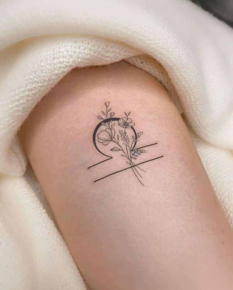 4. Ein Tattoo mit dem Symbol der Waage und Blumen