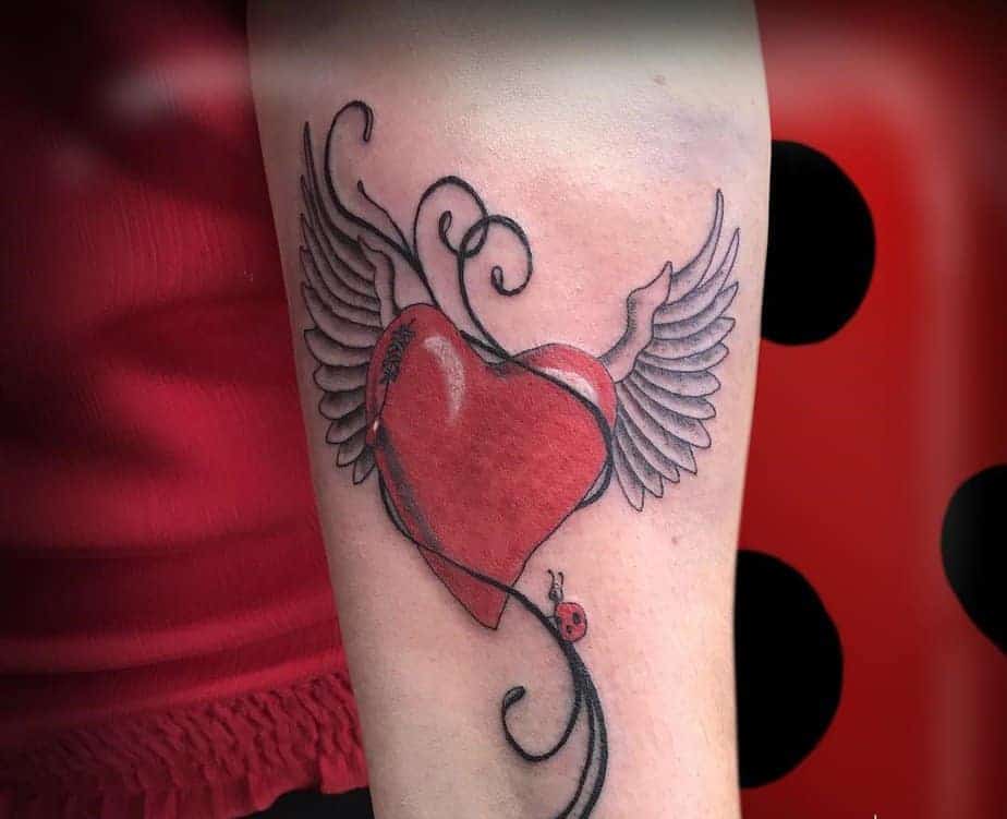 17. Rotes Herz mit Flügeln und Marienkäfer-Tattoo