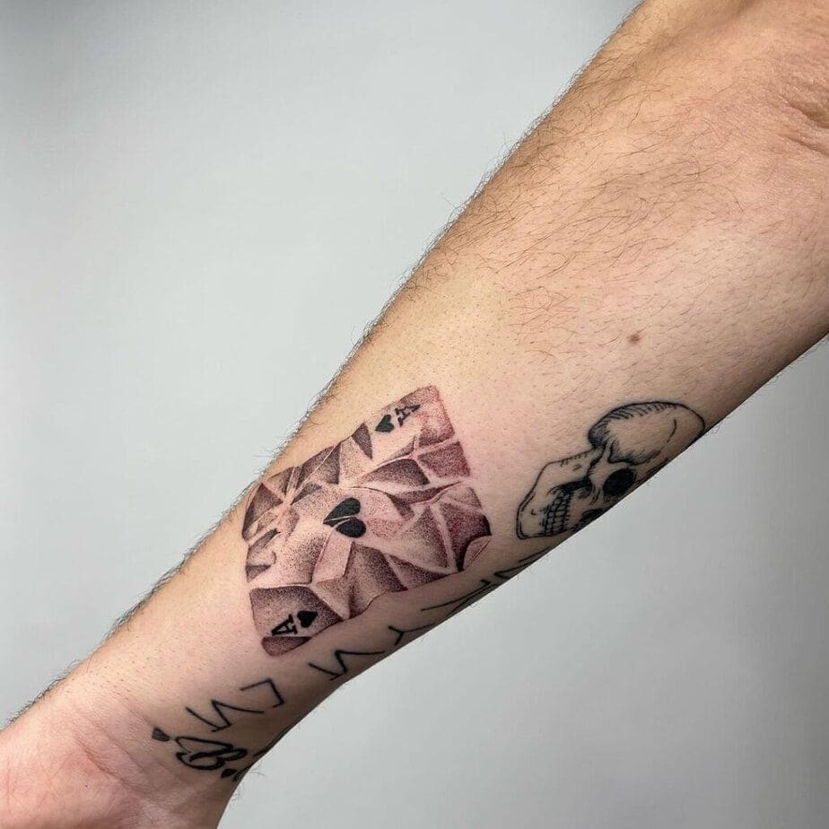 9. Ein zerknittertes Pik-As-Tattoo auf dem Arm