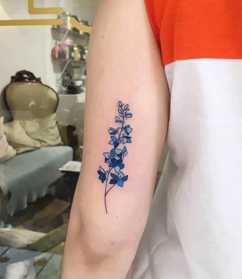 14. Leuchtend blaues Rittersporn-Tattoo auf dem Arm