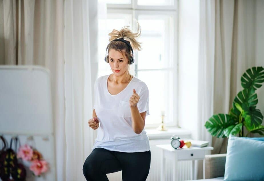 Woman wearing headphones and dancing in her home.