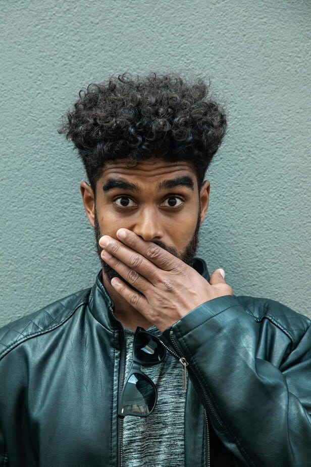 Sich den Mund zuhalten, um ein Lachen zu verbergen